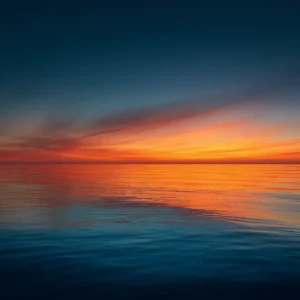 Photographie d'un couche de soleil sur un mer calme