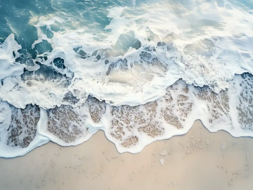 Photographie aérienne de vagues se brisant sur le sable
